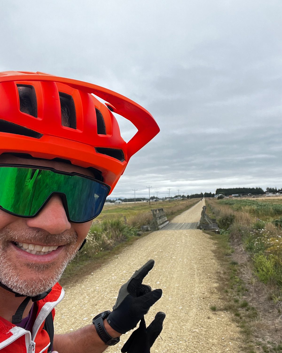 Doug pointing down a long gravel trail